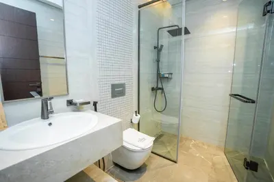 a bathroom with a toilet and a sink and a shower at Luxury 1BR in Nobles Tower Business Bay in Dubai