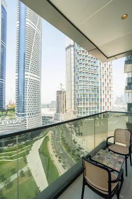 a balcony with two chairs and a view of a city at Luxury 1BR in Nobles Tower Business Bay in Dubai