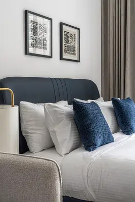 a bed with blue and white pillows on it at Modern Studio I Smart Home I Business Bay in Dubai