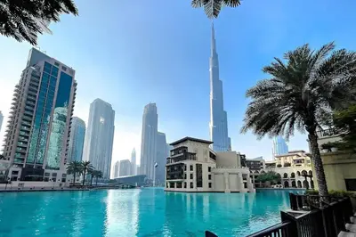 a large swimming pool in a city with tall buildings at Luxury 2BR- Pool with Burj View- 2 Min to Dubai Mall in Dubai