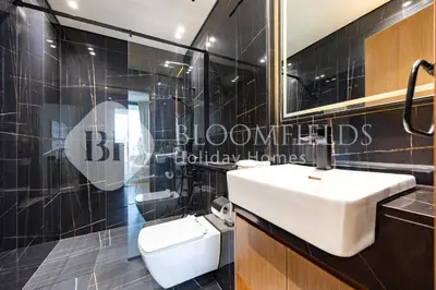 a bathroom with a white sink and a toilet at Bloomfields Modern 1Br Binghatti Onyx in Dubai