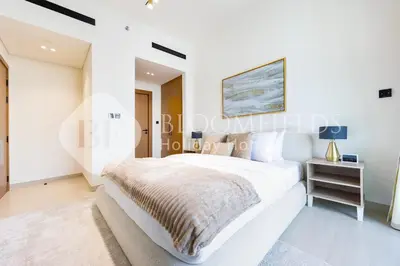 a white bedroom with a bed and a table at Bloomfields Modern 1Br Binghatti Onyx in Dubai