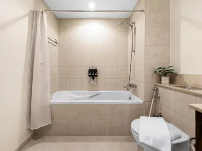 a bathroom with a tub and a toilet at Luxury two Bedroom Apartment I Front row Downtown with Private Fountain & Burj View by Luxury Space in Dubai