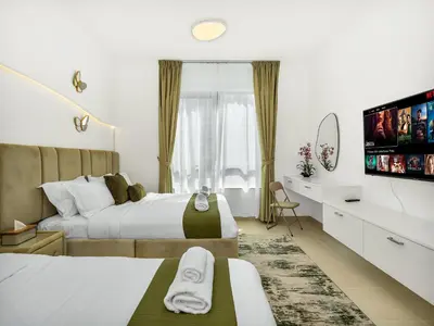 a bedroom with two beds and a flat screen tv at Luxury two Bedroom Apartment I Front row Downtown with Private Fountain & Burj View by Luxury Space in Dubai