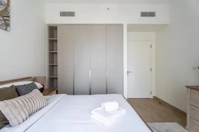 a white bedroom with a bed with a white towel on it at GuestReady - Charming stay at Creek Beach in Dubai