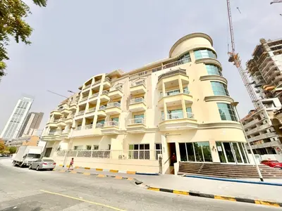 a large white building on a city street at Homes2Retreat - Modern Studio with Balcony in JVT in Dubai