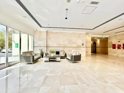 a lobby with couches and a table in a building at Homes2Retreat - Modern Studio with Balcony in JVT in Dubai