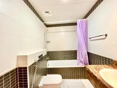 a bathroom with a tub and a toilet and a sink at Homes2Retreat - Modern Studio with Balcony in JVT in Dubai