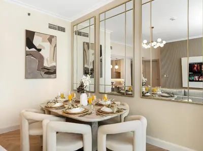a dining room with a table and white chairs at Kensington 2BR walk to Dubai Mall via Link in Dubai