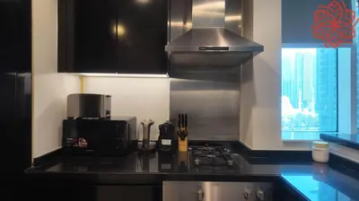 a kitchen with a stove top oven next to a window at pearl 1bdr apartment in business bay in Dubai