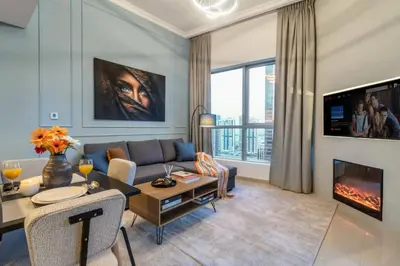 a living room with a couch and a fireplace at Panoramic Marina Views Walk to Beach and JBR 1BR in Dubai
