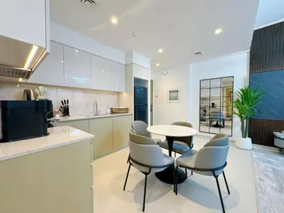 a kitchen and dining room with a table and chairs at Stylish & Comfy Downtown Oasis Views, Pool & Gym in Dubai