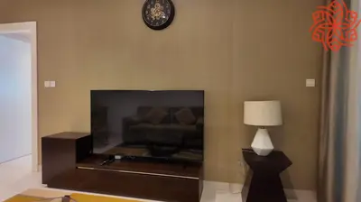 a living room with a couch and a clock on the wall at Amazing 1bdr apartment in business bay in Dubai