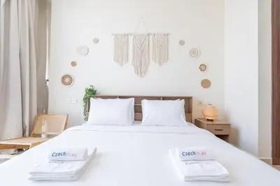 a bedroom with a white bed with two towels on it at Bright and Cozy 1BHK JVC by Czechin Great Location in Dubai