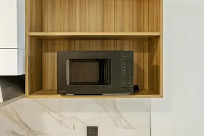 a microwave oven on a shelf in a kitchen at BLVD Boutique Style Apartment Gym Pool Balcony JVC in Dubai