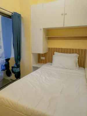 a bedroom with a white bed and a cabinet at Modern Private Hostel Room near Business Bay Downtown in Dubai