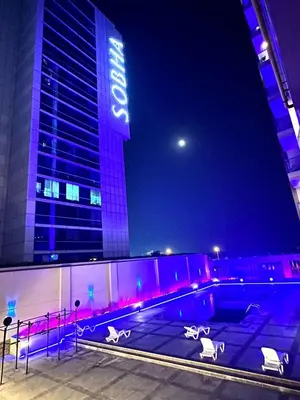 a swimming pool in front of a building at night at Modern Private Hostel Room near Business Bay Downtown in Dubai