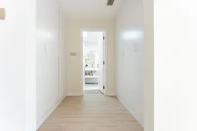 an empty hallway with white walls and wood floors at Veluxa - Beautiful 2Bed in JBR in Dubai