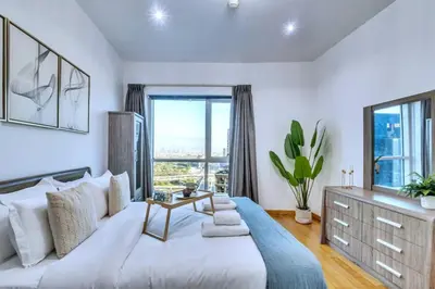 a bedroom with a large white bed and a large window at Marina View, 2BR Ideal for Groups, Walk to beach in Dubai