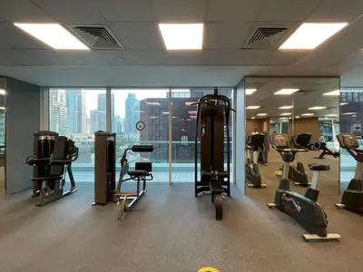 a gym with cardio equipment in a building at Family and Group Friendly Near Beach Metro and Marina in Dubai