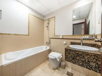 a bathroom with a tub and a toilet and a sink at Comfy 2BR Amwaj 4 Sleeps 10 in Dubai