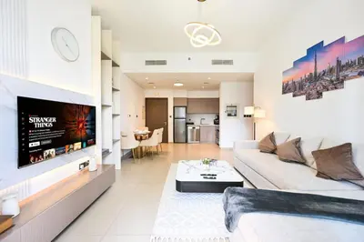 a living room with a couch and a tv at Modern 1BR in ACT Tower 1 in Dubai