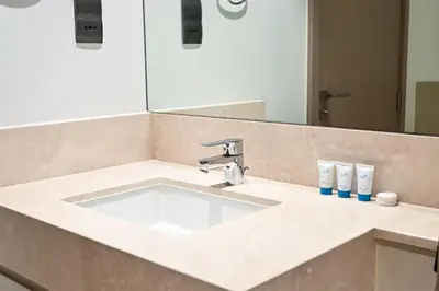 a bathroom counter with a sink and a mirror at Modern 1BR in ACT Tower 1 in Dubai