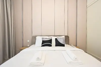 a bedroom with a white bed with black and white pillows at Modern 2BR Golfville Dubai in Dubai