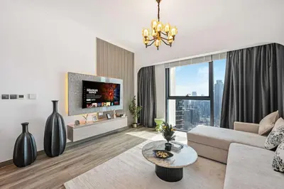 a living room with a couch and a tv at 2BR Pool Burj View Dubai Mall in Dubai