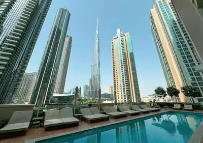 a pool on the roof of a building with tall buildings at 2BR Pool Burj View Dubai Mall in Dubai