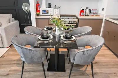 a dining room table and chairs with a black table and chairs at 2BR Pool Burj View Dubai Mall in Dubai