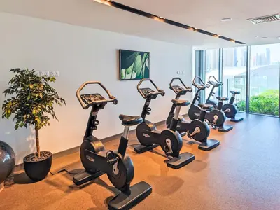 a row of cardio exercise bikes in a gym at Stunning 1 Bedroom at Boulevard Point with Infinity Pool connected to Dubai Mall by Luxury Space in Dubai