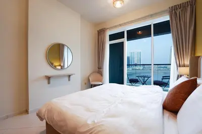 a bedroom with a large bed and a large window at Best Deal I Spacious Apartment I Full Amenities including Balcony, Pool, Gym, Kids Play Area in Dubai