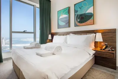 a hotel room with a large bed with towels on it at Maison Privee - Chic Coastal Escape with Open Sea Vws on Palm Entry in Dubai