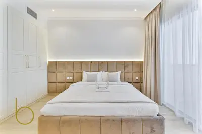a bedroom with a large bed and a large window at Bookable - 3 Bedroom in Mayas Geneva, JVC in Dubai