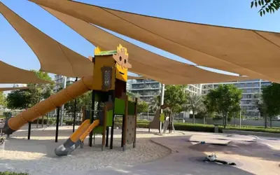 a playground with a slide in a park at FIRST CLASS 2BR Timeless Vibes & Pool View in Dubai