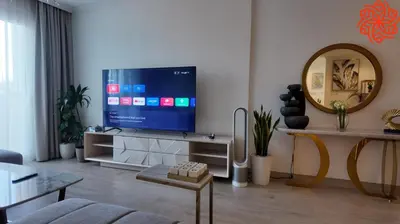 a living room with a flat screen tv on a wall at Amazing 3 bedrooms in Mayas geneva in Dubai