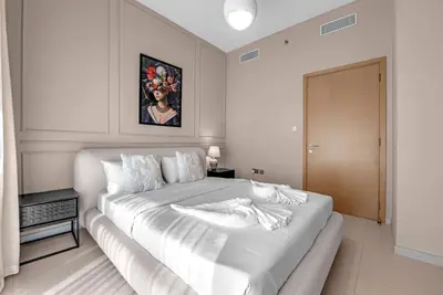 a white bedroom with a large white bed in it at Luxury 2BR Downtown Burj View, Heart of Downtown in Dubai