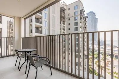 a balcony with a table and chairs and a view of the city at Creek Views 1BR, Short Drive to Ras Al Khor Sanctuary and Festival City Mall, Rosewater at Creek Beach Building 3, Dubai Creek Harbour by Deluxe Holiday Homes in Dubai