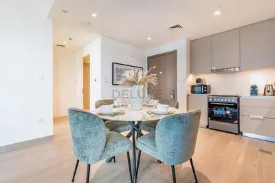 a kitchen and dining room with a table and chairs at Creek Views 1BR, Short Drive to Ras Al Khor Sanctuary and Festival City Mall, Rosewater at Creek Beach Building 3, Dubai Creek Harbour by Deluxe Holiday Homes in Dubai