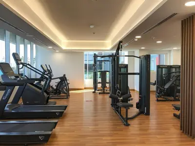 a gym with several tread machines in a room at Frank Porter - Bloom Tower C in Dubai