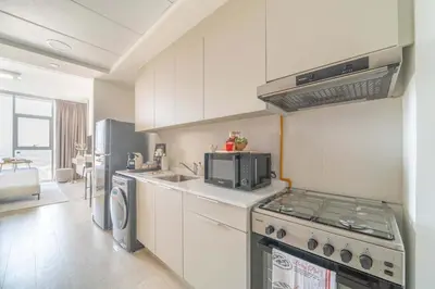 a kitchen with white cabinets and a stove top oven at Frank Porter - Bloom Tower C in Dubai