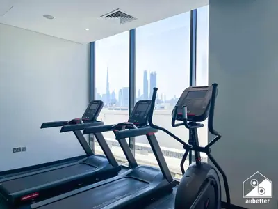 two treadmills in a gym with a large window at Elegant 1BR at Azizi Riviera l Prime Location in Dubai