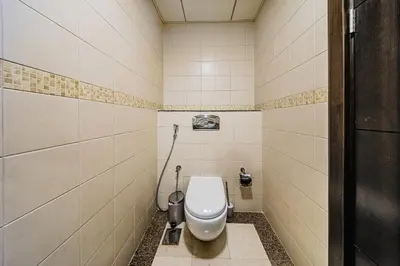 a bathroom with a white toilet in a stall at 1BD Canal View for 4 in Bay Central, Dubai Marina in Dubai