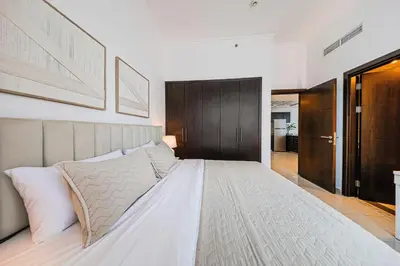 a bedroom with a large white bed with white pillows at 1BD Canal View for 4 in Bay Central, Dubai Marina in Dubai