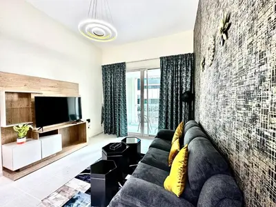a living room with a couch and a tv at Stylish 1 Plus Maid's 5 mins to Metro at Marina Park in Dubai