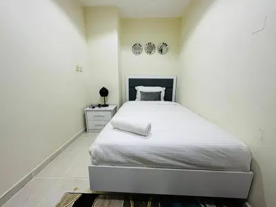 a bedroom with a large bed with white sheets at Stylish 1 Plus Maid's 5 mins to Metro at Marina Park in Dubai