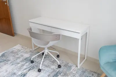 a white desk and a chair in a room at Stylish 1BR DunyaTower Apartment 2min to DubaiMall in Dubai