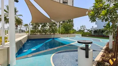 a swimming pool with an umbrella on top of a building at Vogue Damac Hills Golf Gate near First Avenue Mall, Two Bedroom Apartment with Balcony and Vibrant Community View, Access to all Amenities in Dubai
