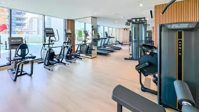 a gym with treadmills and exercise equipment in a building at TRPS - Binghatti Lavender, JVC - Premium 1BR Retreat, Fully Furnished in Dubai